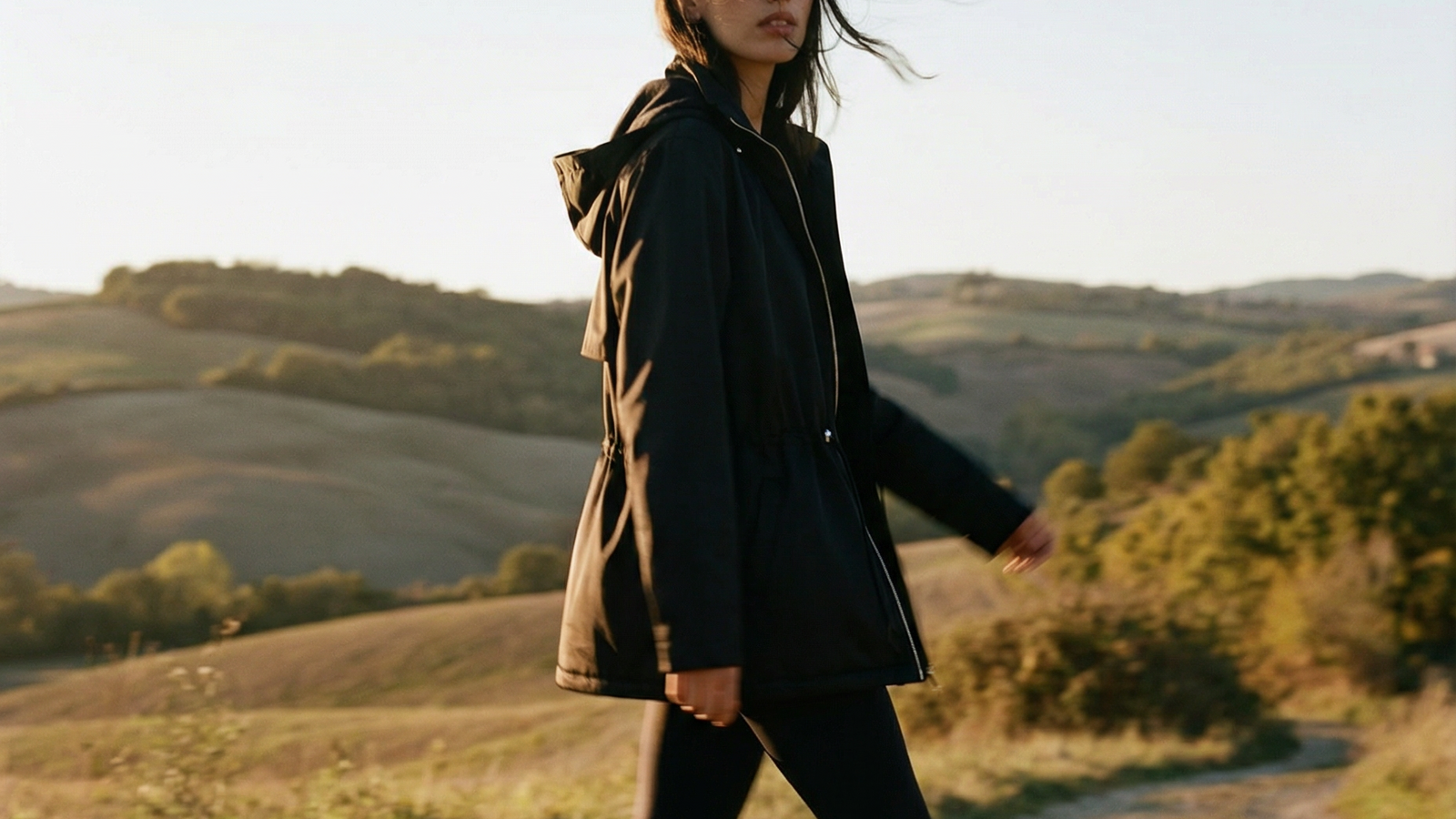 Woman walking on a dirt path in a scenic outdoor setting